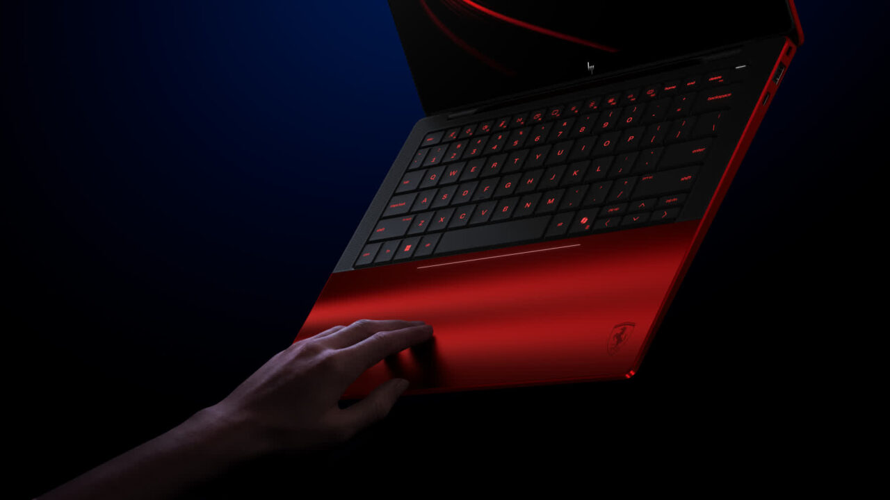 1000040783 Hand resting on the touchpad of a red backlit gaming laptop in a dark, moody setting.